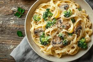 Tagliatelle pasta with creamy sauce, mushrooms, and broccoli served in a bowl photo