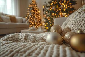 Christmas balls resting on knitted blanket with christmas trees in background photo