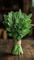 Bouquet of fresh sage tied with twine on rustic wooden table photo