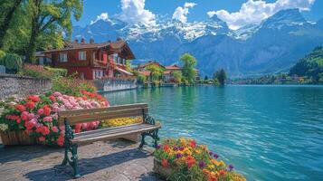 Wooden bench inviting you to sit and enjoy the view of the swiss alps reflecting in the lake photo