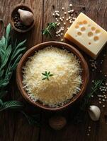 Grated parmesan cheese in a wooden bowl with basil garnish photo