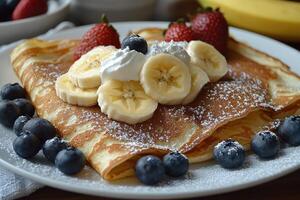 Delicious homemade banana pancakes being topped with whipped cream and chocolate photo