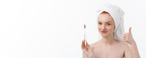 Portrait of young woman with toothbrush on grey background. photo
