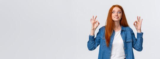Excited and happy fascinated redhead woman looking pleased and astonished, visit awesome favorite movie, showing okay gesture, review amazing party, smiling and staring thrilled photo