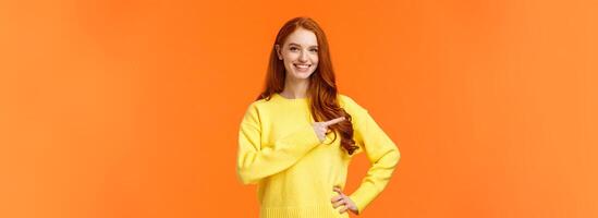 Shopping, consumer and holidays concept. Cheerful attractive redhead woman in yellow sweater invite check-out shopping mall sale, pointing left, presenting product, advice click link, smiling photo