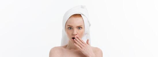 Surprised Beautiful Young Woman After Bath with A Towel On Her Head Isolated On white Background. Skin Care And Spa Theme. photo