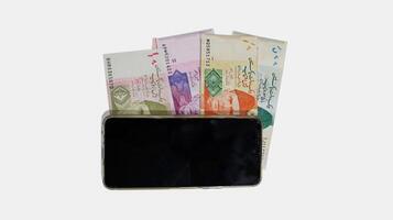Pakistani currency bank notes aligned with mobile phone in sequence 10 20 50 100 500, Pakistan State Bank official currency notes isolated on a white background photo