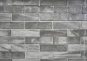 Grungy gray brick wall background building exterior texture material isolated on horizontal ratio background. photo