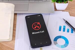 A mobile phone on a desk with a missed call notification on the phone screen photo