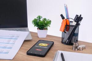 A mobile phone on a office desk with a new message notification on the phone screen photo