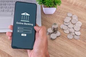Male hand holding a smartphone to access online mobile banking. Enter username and password to access mobile banking. photo