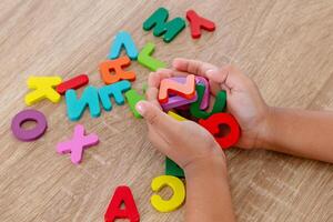 Close up view of a handful of wooden alphabet letters in the palm of a little girl's hand photo