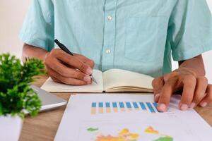 Man writes a summary of the analysis of a graph from a jobs report photo