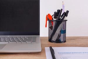 Close up view of desk workplace with stationery, laptop, and paperwork photo