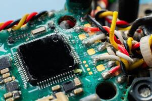 Close-up macro of drone flight controller microprocessor with broken wire. Microelectronics repair. photo
