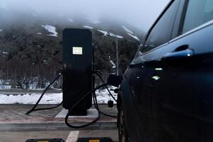 Using a charging station. Renewable energy concept. Electric car using sustainable source. Saving, climate change photo