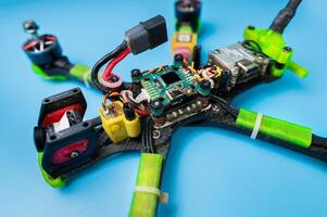 Disassembling a self-assembled FPV drone for repair. Quadcopter under repair. Removing the upper carbon frame cover. photo