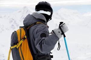 ski background, skier in beautiful mountain landscape, winter holidays in the Alps. unrecognizable person stands with his back to the frame and looks into the distance into the mountain photo