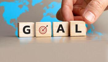 Goal Achievement Concept with Wooden Cubes and Target Symbol, Business Strategy and Success Visualization, Hand Setting Goal Block with World Map in Background. photo