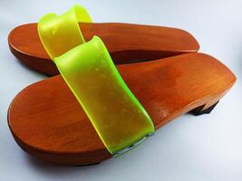 This is a pair of gapyak sandals with a white background. Made from wood, it is a traditional sandal from Indonesia that can be worn by both men and women photo