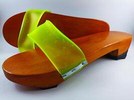 This is a pair of gapyak sandals with a white background. Made from wood, it is a traditional sandal from Indonesia that can be worn by both men and women photo