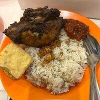 Indulging in the aromatic flavors of nasi uduk paired with juicy ayam bakar. A true Indonesian feast on my plate photo