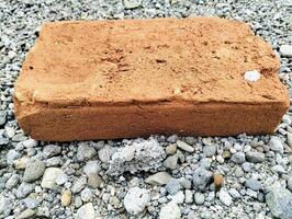 Rustic Clay Bricks Displaying Textures and Wear on Pebble Ground photo