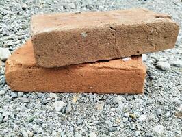 Worn Clay Bricks on a Pebbled Ground, Capturing the Essence of Rustic Construction photo