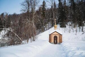 A small wooden church nestled in a snowy forest landscape photo