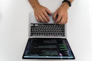 An overhead view of the hands of a man working at a computer photo
