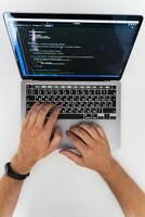 An overhead view of the hands of a man working at a computer photo