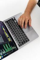 A programmer typing on a laptop with one hand photo