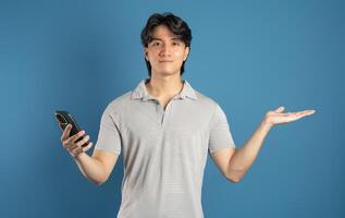 Portrait of asian man posing on blue background photo