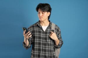 Portrait of Asian male student posing on blue background photo
