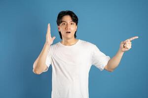 Portrait of asian man posing on blue background photo