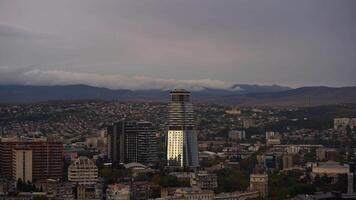 Timelapse of running clouds on the Tbilisi skyline at dusk with mountains and colorful architecture video