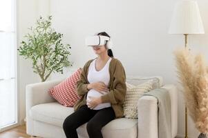 Pregnant woman wearing vr box using future technology for entertainment in living room photo