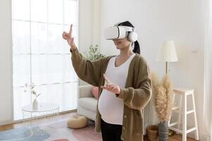 Pregnant woman wearing vr box using future technology for entertainment in living room photo