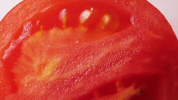 Tomato rotation in macro shot on white background video