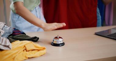 Selective focus, Young asian woman live-streamed selling clothes and pressed a bell to attract customers' attention in home studio. Remote buying, Online shopping. photo