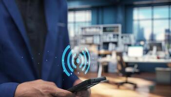 Man in suit holding smart phone with wireless network symbol photo