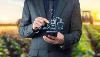 Man in suit holding smartphone with farm image photo