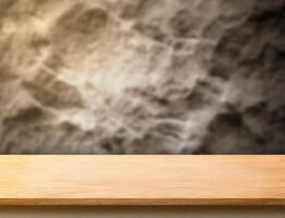 wooden plank table top at blurred rough stone wall,Template mock up for display or montage of product. photo