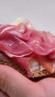 prosciutto sandwich ciabatta sandwich with sliced ham, on paper, rotating video