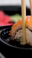 sushi delivery Sticks take sushi from sushi box. Rolls in plastic box. Ready-to-eat set of various delicious Japanese sushi rolls in delivery container. Concept healthy eat, Asian food, takeaway meal video