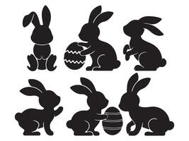 Set of black silhouettes of rabbits with easter eggs vector
