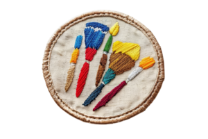 Colorful fabric patch featuring embroidered paintbrushes on a beige background, perfect for art enthusiasts and DIY projects. png