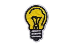 Lightbulb patch icon with a yellow bulb and black outlines, perfect for creativity and innovation concepts, isolated on transparent background. png