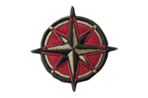 Close-up image of an embroidered compass rose patch with red and black details, isolated on a transparent background. png