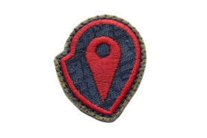 Embroidered patch with a red location pin design on a black fabric background, perfect for decoration or customization. png
